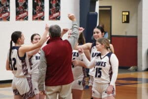 Girls basketball team in a huddle, ready to break